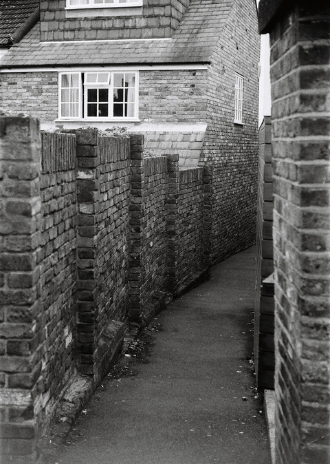 A brick walled alleyway in the town of Teddington, London