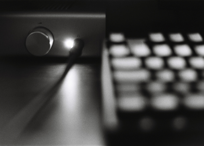 A headphone amplifier and keyboard on a desktop