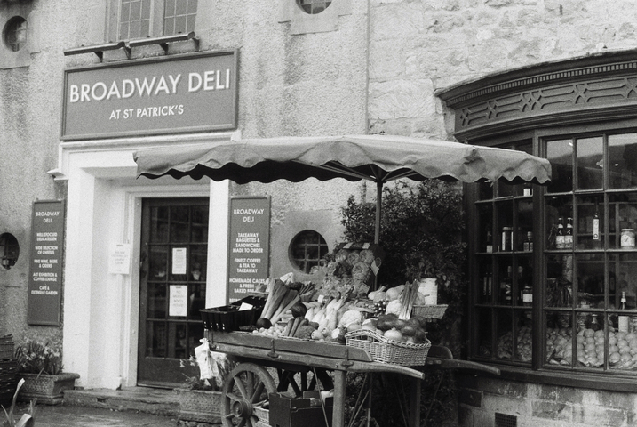 The broadway deli in St. Patricks with a traditional wooden fruit and vegetable cart outside