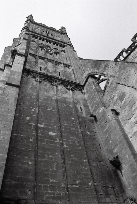 Church or cathedral bell tower with clock and large stone buttress