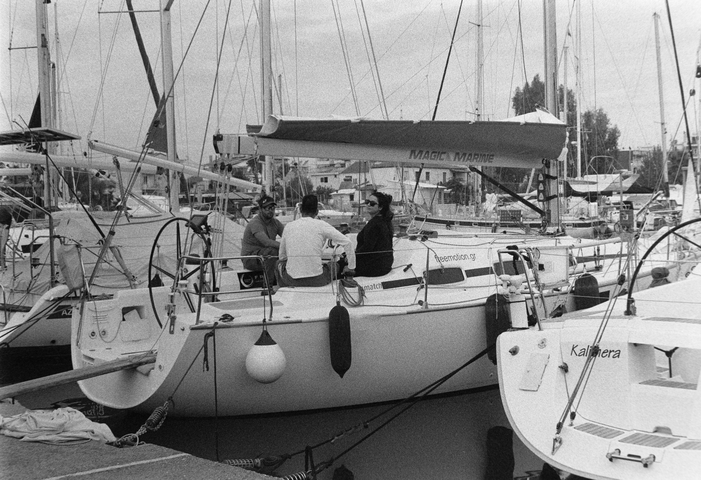 Three people sat on a moored yacht in Kalamata marina