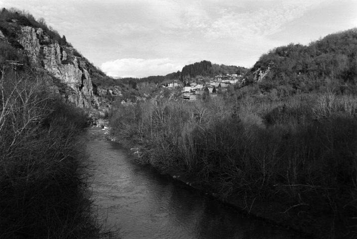 The tree lined Voidomatis river leading to the town of Kipoi in the distance