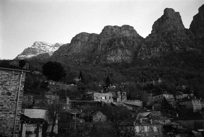 Mikro Papigo with tall snow topped rocky mountains behind