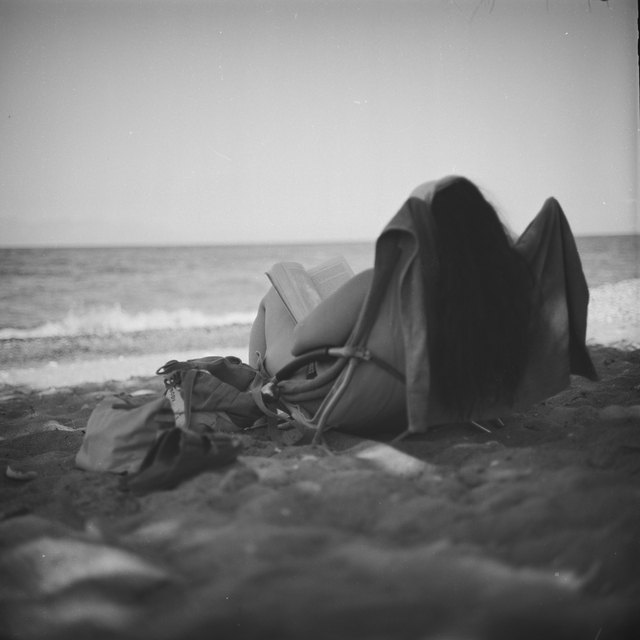 Vicky relaxing on the beach reading a book