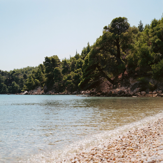 A view across the pebbled beach of Tzortzi Gialos beach